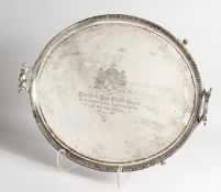 A LARGE GEORGE III TWO HANDLED TEA TRAY, 25ins long, with gadrooned edge, scrolling handles on 4