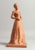 A 20TH CENTURY TERRACOTTA MODEL OF A YOUNG LADY, standing wearing a long dress, indistinctly