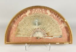 A FRAMED AND GLAZED FRENCH FAN in lace over mother of pearl 13ins x 22ins