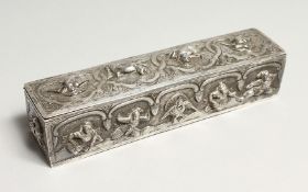 A BURMESE SILVER LONG BOX AND COVER with figures in relief 7ins long