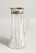 A SILVER MOUNTED GLASS JUG. 9.5ins high