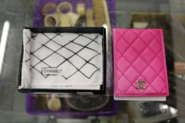A pink quilted leather credit card case.
