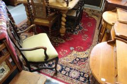 A large Persian style carpet, red ground with floral decoration.