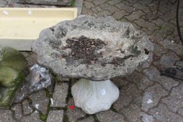 A shell shaped reconstituted stone bird bath.