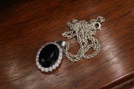 A silver pendant and chain.