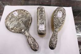 A silver backed dressing table mirror and two other items.