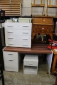A white wood four drawer bedroom chest, a similar desk or dressing table and a bedside cupboard.