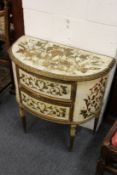 A continental style painted and gilded demi-lune two-drawer commode.