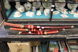 A set of three reproduction Japanese swords.