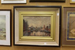 A continental river landscape with buildings oil on board, signed.
