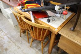 A pine, tile topped kitchen table and four chairs.