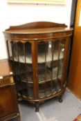 A mahogany bow front display cabinet.