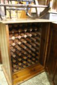 A pine cupboard containing a wine rack.