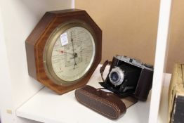 A folding camera and a barometer.