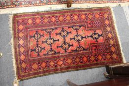 A small red ground Persian rug.