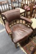 A Victorian oak framed and leather cloth upholstered desk chair.