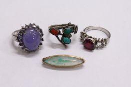 Three silver rings and a decorative brooch.