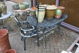 A painted cast aluminium patio table and an armchair.