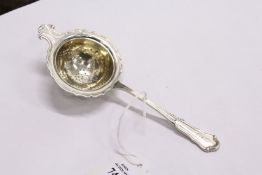 A silver tea strainer.
