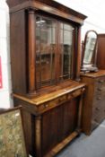 A William IV mahogany cupboard bookcase with column supports, the base with two drawers and two