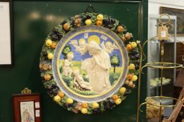 A good large Della Robbia pottery plaque depicting a religious scene, the border with a wreath of