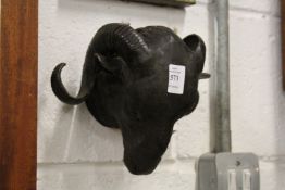 A cast bronze model of a ram's head.