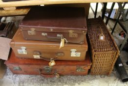 Three suitcases and a wicker hamper.