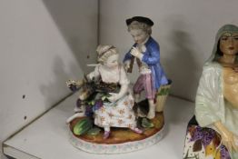 A 19th century continental porcelain group of a young boy and girl, a goat by their side.