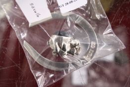 A silver horseshoe and a pig pin cushion.