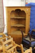 A large pine corner cupboard.