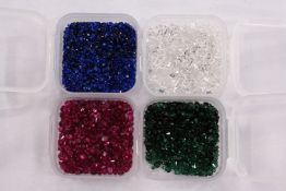 Four small boxes of clear and coloured spinels.