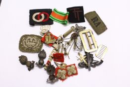 A quantity of military cap badges, buckles and other related items.