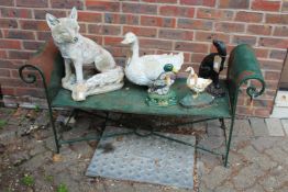 A green painted metal garden bench.