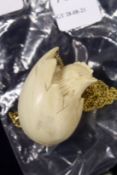 An amusing pendant and chain modelled as a chick in a shell.