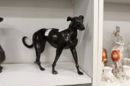 A bronze model of a standing dog.