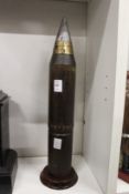 An early military shell mounted on a mahogany plinth base.