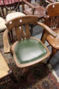 An Edwardian oak swivel armchair.