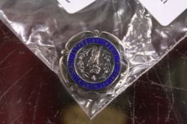A silver and enamel General Nursing Council brooch.