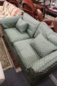 A classic style large two-seater green upholstered settee.