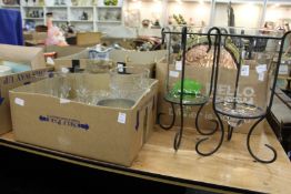 A pair of glass storm lanterns and other glassware.