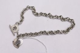 A silver necklace with heart shaped decoration.