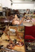 A pair of copper angle poise lamps.
