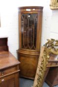 A mahogany standing corner cabinet.