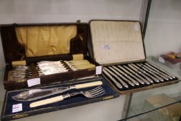 A cased set of silver handled fruit knives, a cased set of fish servers and a cased set of fish