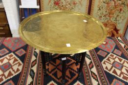 An eastern brass tray top table with folding base.