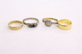 A 22ct gold small wedding band and three other rings.
