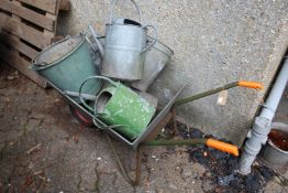 A wheelbarrow and a quantity of galvanized watering cans and buckets.