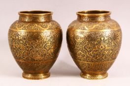 A PAIR OF PERSIAN BRASS VASES, with profusely engraved and chased decoration, 17cm high.