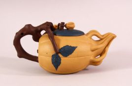 A CHINESE YIXING CLAY TEAPOT - with a beige ground, the pot in the form of a fruit, with vine growth