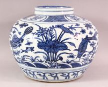 A CHINESE BLUE & WHITE PORCELAIN FISH POT - decorated with fish and lotus, 20.5cm high.